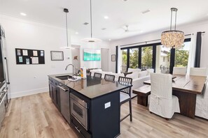 A modern kitchen with a central island, built-in oven, and stainless steel appliances. - 🛺 Sun of a Beach - 5BR + Golf Cart + Bikes + Rooftop Hangout (Santa Rosa Beach)