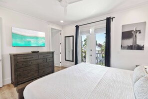 A bedroom with a large bed, a dresser, a television on the wall, and a balcony with a view. - 🛺 Sun of a Beach - 5BR + Golf Cart + Bikes + Rooftop Hangout (Santa Rosa Beach)