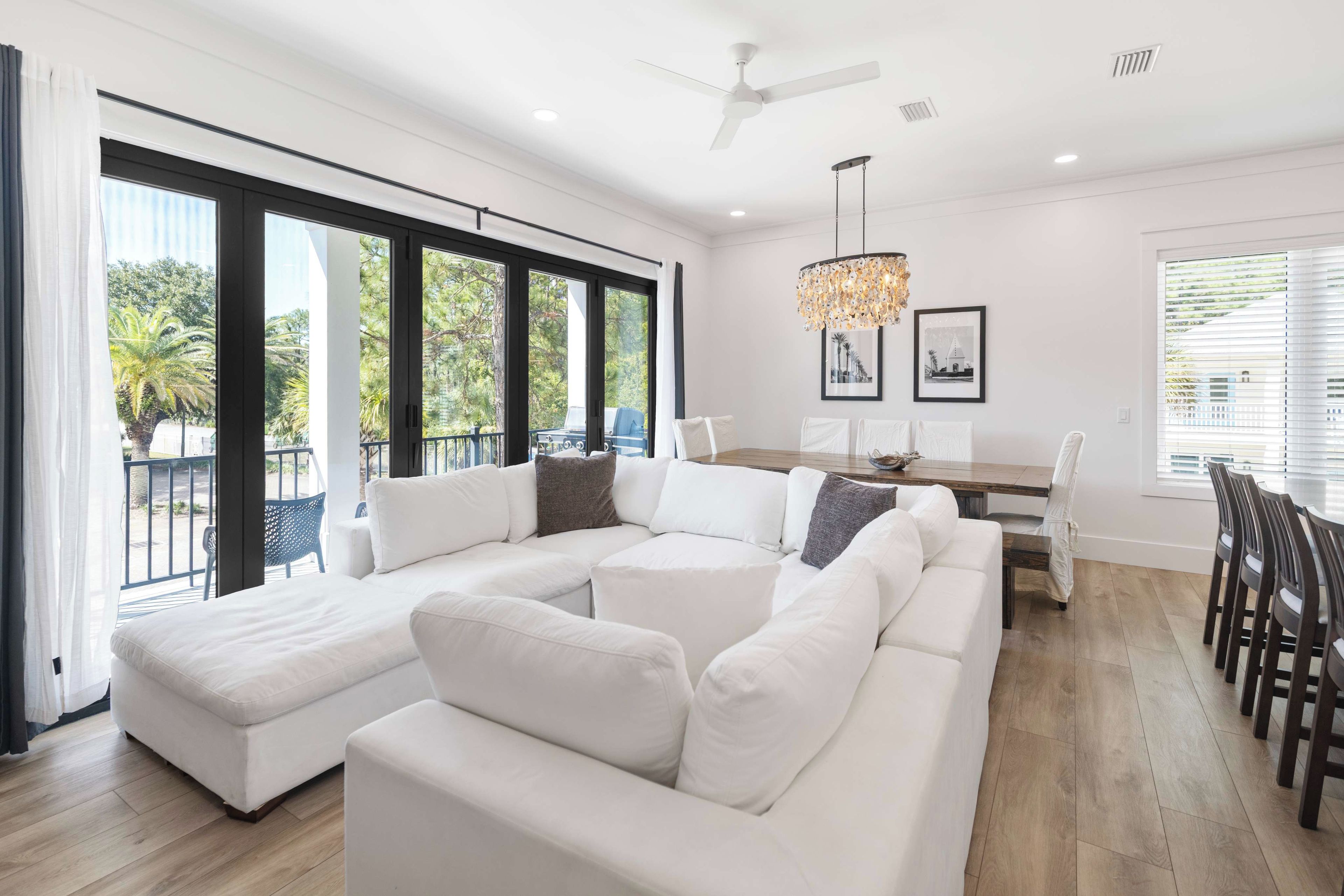 A modern living room with a sectional sofa, dining area, and large windows.