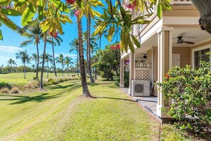 A house with a covered porch, a lawn, and palm trees. - Updated | 1st Floor | Hilton Pool | Sunset Views (Waikoloa Village)