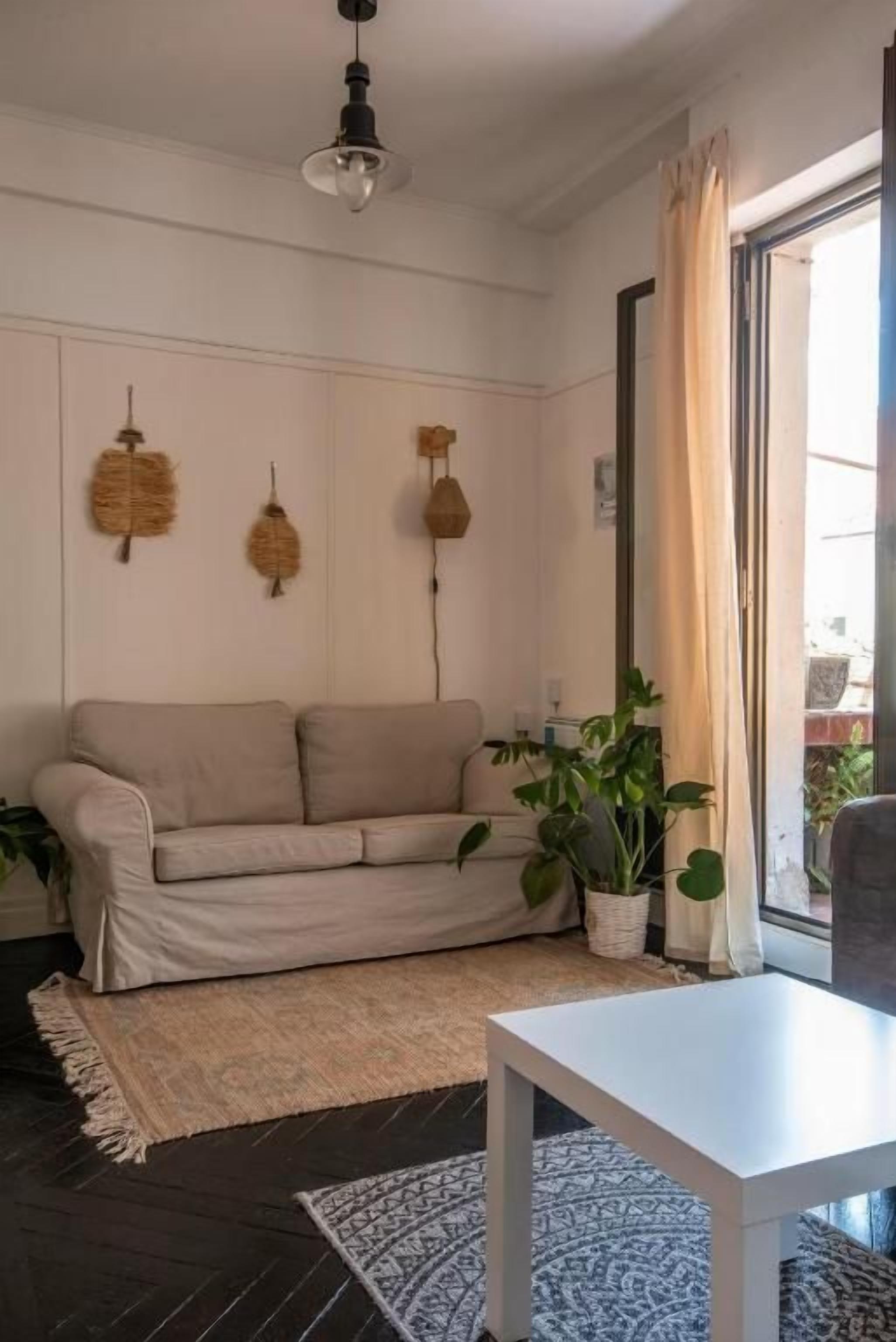 Una sala de estar con un sofá, una mesa y una planta en maceta.