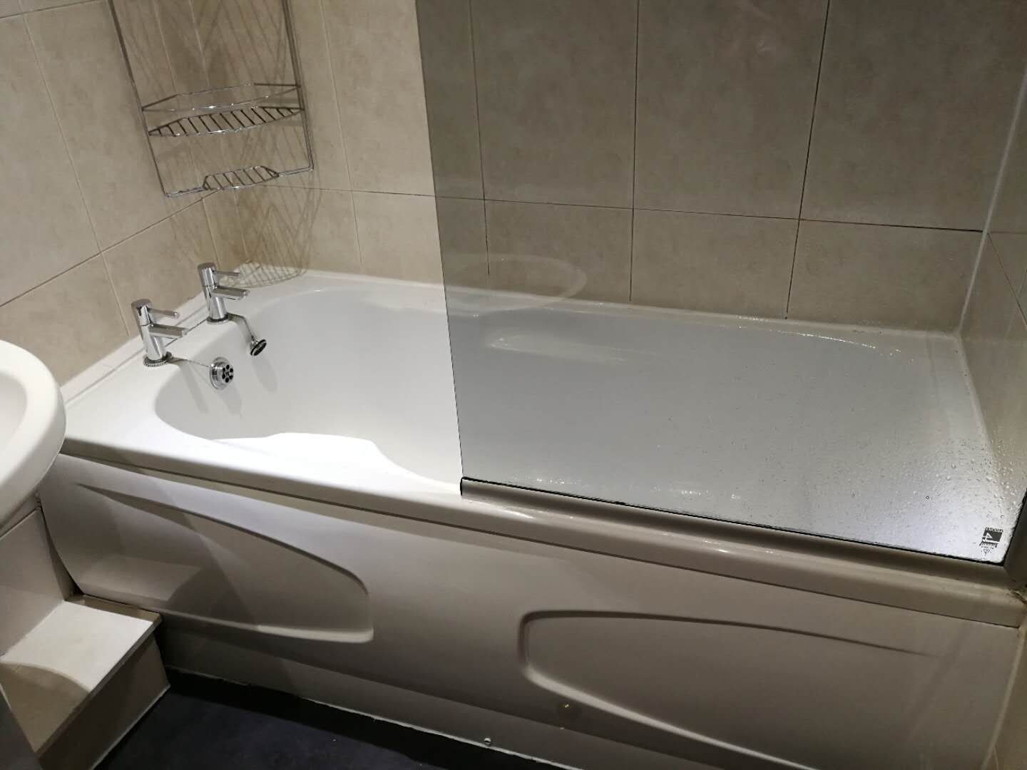 Een badkamer met een bad, een wastafel en een spiegel.