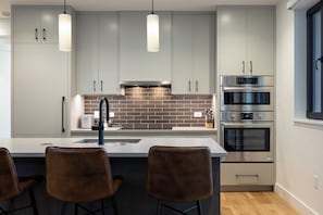 Step into your sleek, modern kitchen where everything you need is at your fingertips. Gleaming appliances, stylish pendant lighting, and an inviting island make this the perfect spot to whip up a meal or enjoy your morning coffee. - AMB203 | Dog Friendly | New Luxury Complex | Hot Tub | Winter Shuttle (Steamboat Springs)
