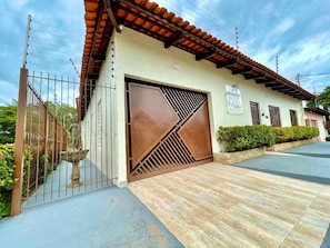 Un edificio con entrada porticada, techo de tejas y un letrero que indica que es un negocio.
