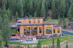 A modern two-story house with a deck, large windows, and a stone foundation. - Private Luxury Mountain Retreat 3 bdrm w hot tub—near Big Sky & Yellowstone (Big Sky)