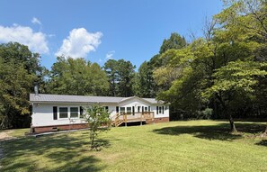 A single-story house with a front porch, surrounded by a grassy yard and trees. -  Private 5acre 3bdrm home close  to golfing, fishing, shopping near Augusta Ga (Appling)
