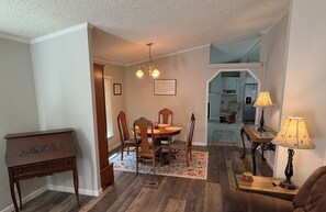 A dining area with a wooden table and chairs, a chandelier, and a rug. -  Private 5acre 3bdrm home close  to golfing, fishing, shopping near Augusta Ga (Appling)