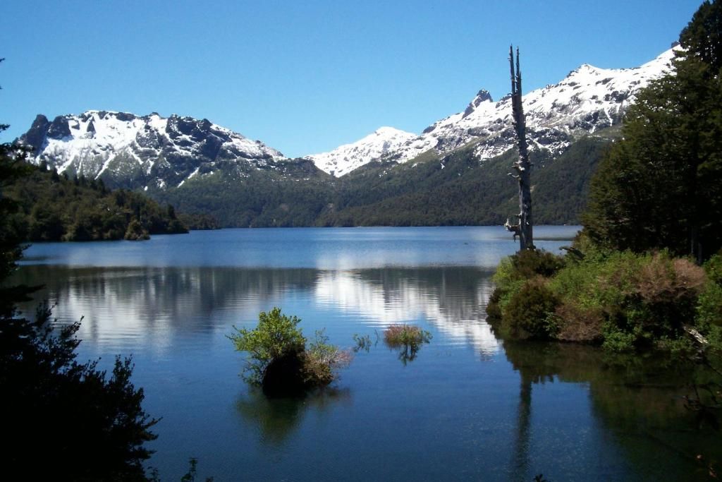 A calm lake with mountains in the background.