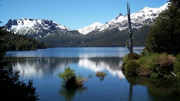 Un lago tranquilo con montañas al fondo.