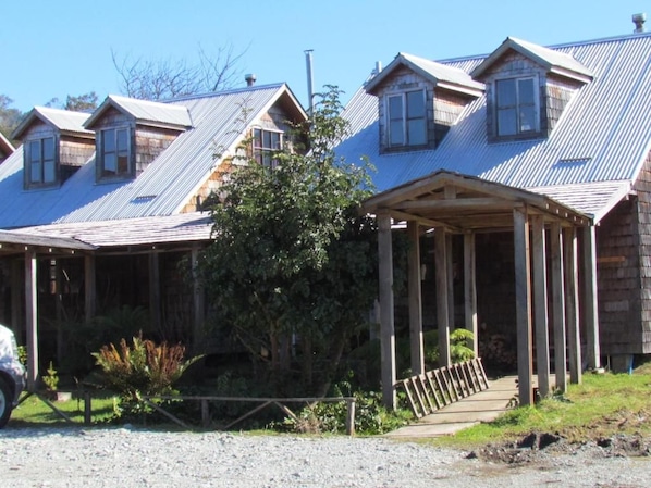 A row of wooden buildings with pitched roofs and a covered porch.