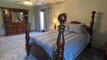 Une chambre à coucher avec un lit à baldaquin, un ventilateur de plafond, une commode et un miroir.