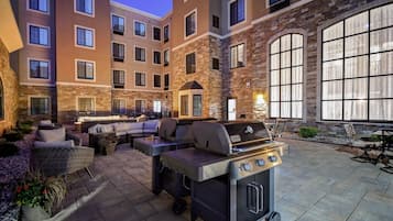 Ein Innenhof mit Grill, Sitzgelegenheit und Steinmauern.