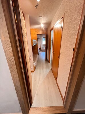 A narrow hallway with wooden walls and a door on the right. - Cozy studio, close to the slopes and shops, Méribel (Les Allues)