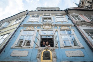 A building with ornate architectural details, including a balcony with a decorative arch and a window with a gold frame. - Charles Bridge Hostel & Apartments (Prague)