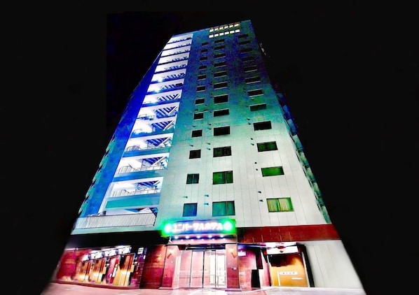 A multi-story hotel with a modern design, featuring a prominent entrance with a neon sign. - Himeji Ekimae Universal Hotel Minamiguchi (Himeji)