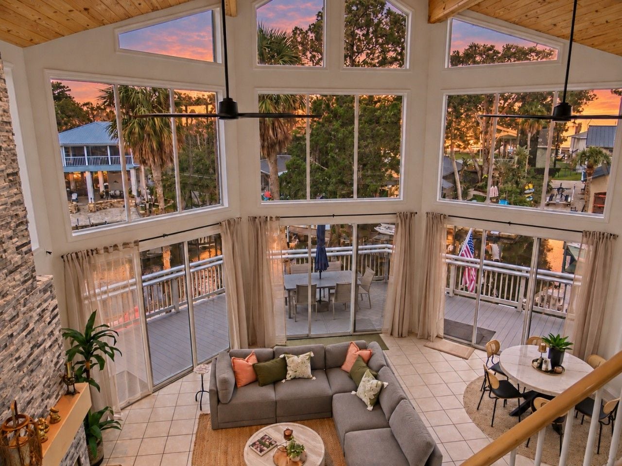 A spacious living area with a large gray sofa, a round coffee table, and a view of the outdoor patio.