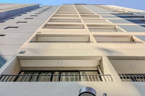 Een modern gebouw met meerdere balkons en een reeks rechthoekige ramen.