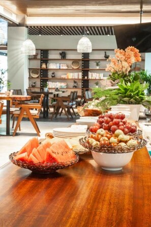 A dining area with a wooden table, a bowl of fruit, and a decorative centerpiece. - Ssaw Boutique Hotel Hangzhou Liangyun (Hangzhou)