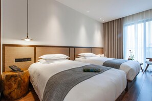 A hotel room with two beds, a bedside table with a phone, a lamp, and a view of the outdoors through large windows. - Ssaw Boutique Hotel Hangzhou Liangyun (Hangzhou)