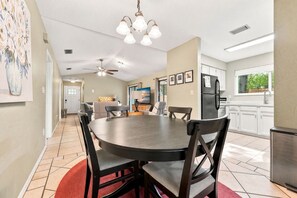 A modern kitchen with a dining area, featuring a round table, chairs, and a ceiling fan. - Near UF & Downtown | Spacious Home + Backyard (Gainesville)