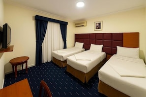 A hotel room with two beds, a TV, a small table, and a chair. - Jawaher Albait Hotel Makkah (Makkah)