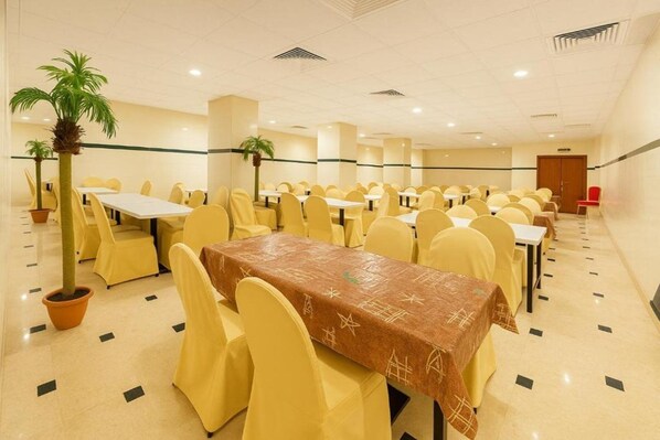 A conference room with multiple tables and chairs, arranged in rows. - Jawaher Albait Hotel Makkah (Makkah)