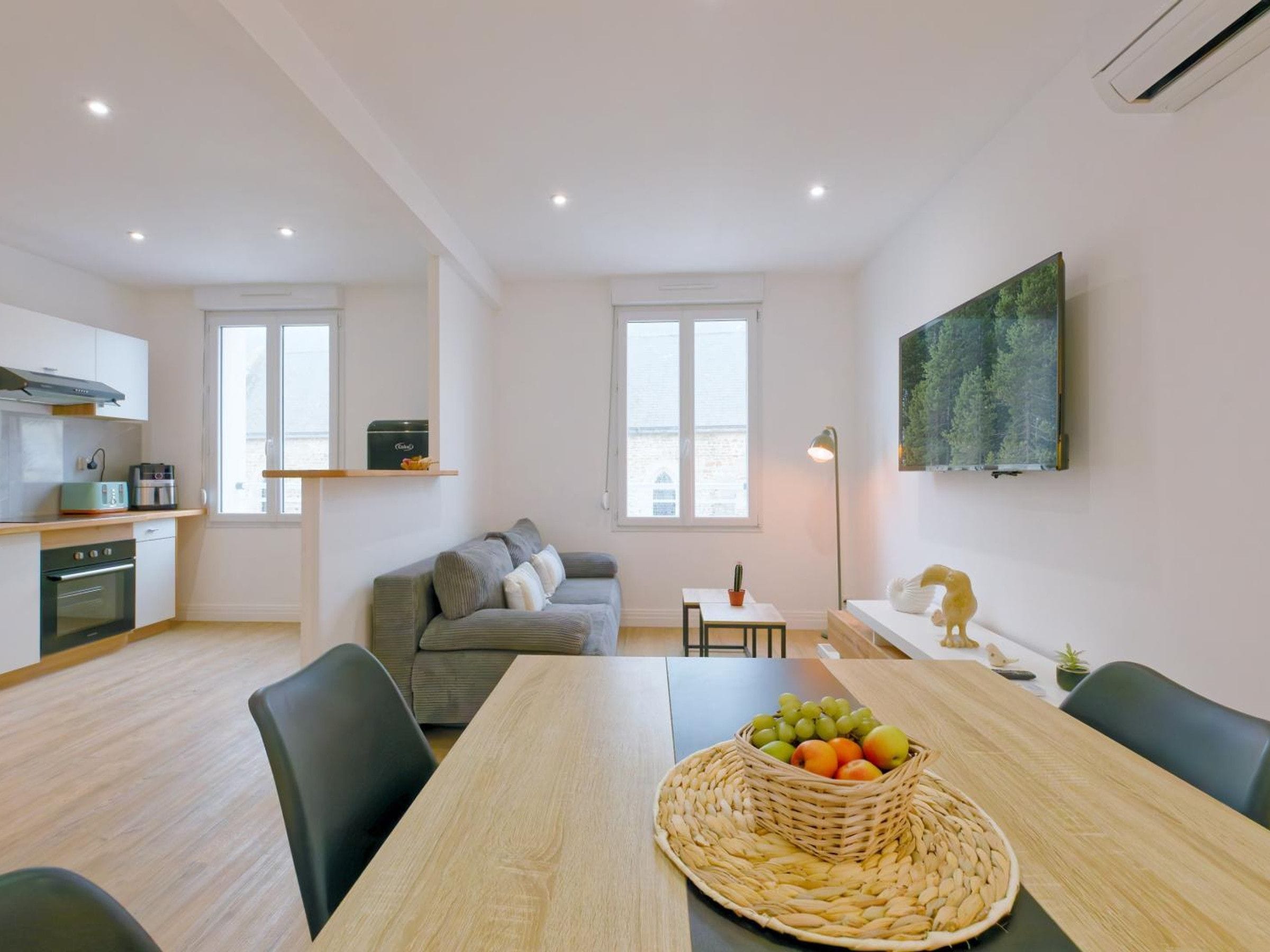 A modern apartment with a kitchen, dining area, and living space.