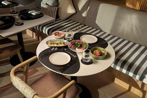 A dining area with a round table set for two, featuring plates, cutlery, and glasses. - Daraah Resort (Al Wajh)