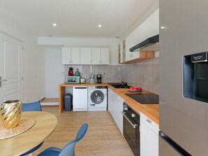 A compact kitchen with a built-in washing machine, a coffee maker, and a toaster. - Apartment with AC and spa in picturesque village (Portbail)