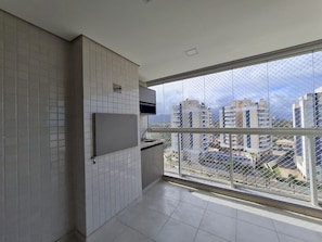 Eine moderne Küche mit großem Fenster, weißen Fliesenwänden und Blick auf eine Stadtlandschaft.