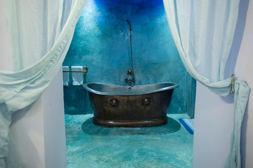 A bathroom with a vintage clawfoot bathtub, a towel rack, and a curtain.