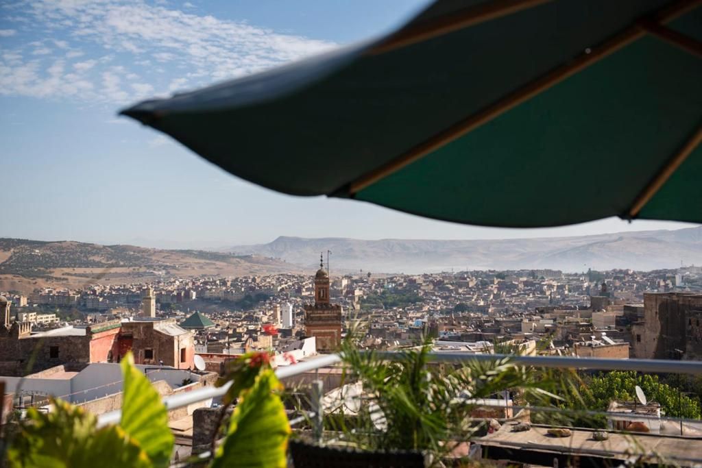A cityscape with a prominent mosque and a view of the city extending to the hills.