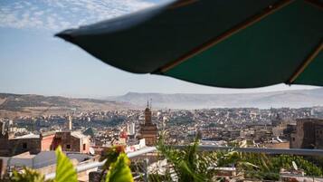 A cityscape with a prominent mosque and a view of the city extending to the hills.