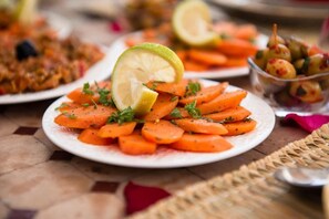 A plate of sliced carrots garnished with herbs and a lime wedge. - Dar Anne – Traditional Guesthouse in Fez (Fès)