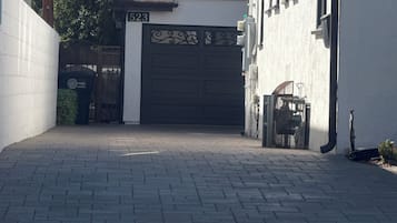 A paved driveway leading to a gated entrance with a number 523 sign.