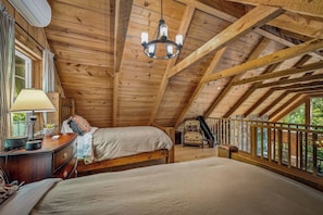 A wooden attic bedroom with a bed, bedside table, lamp, and a telescope. - Mountain River Retreat | Fire Pit, Kayaks & Golf (Mentone)