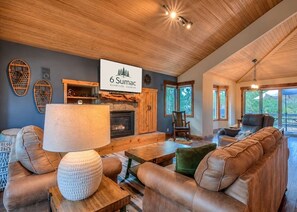 Una sala de estar acogedora con chimenea, asientos cómodos y un letrero con el nombre de la propiedad.