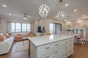 A spacious living room with a white sofa, a dining table with chairs, and a kitchen island. - Lexington luxury -Walk to Rupp-2 parking spaces (Lexington)