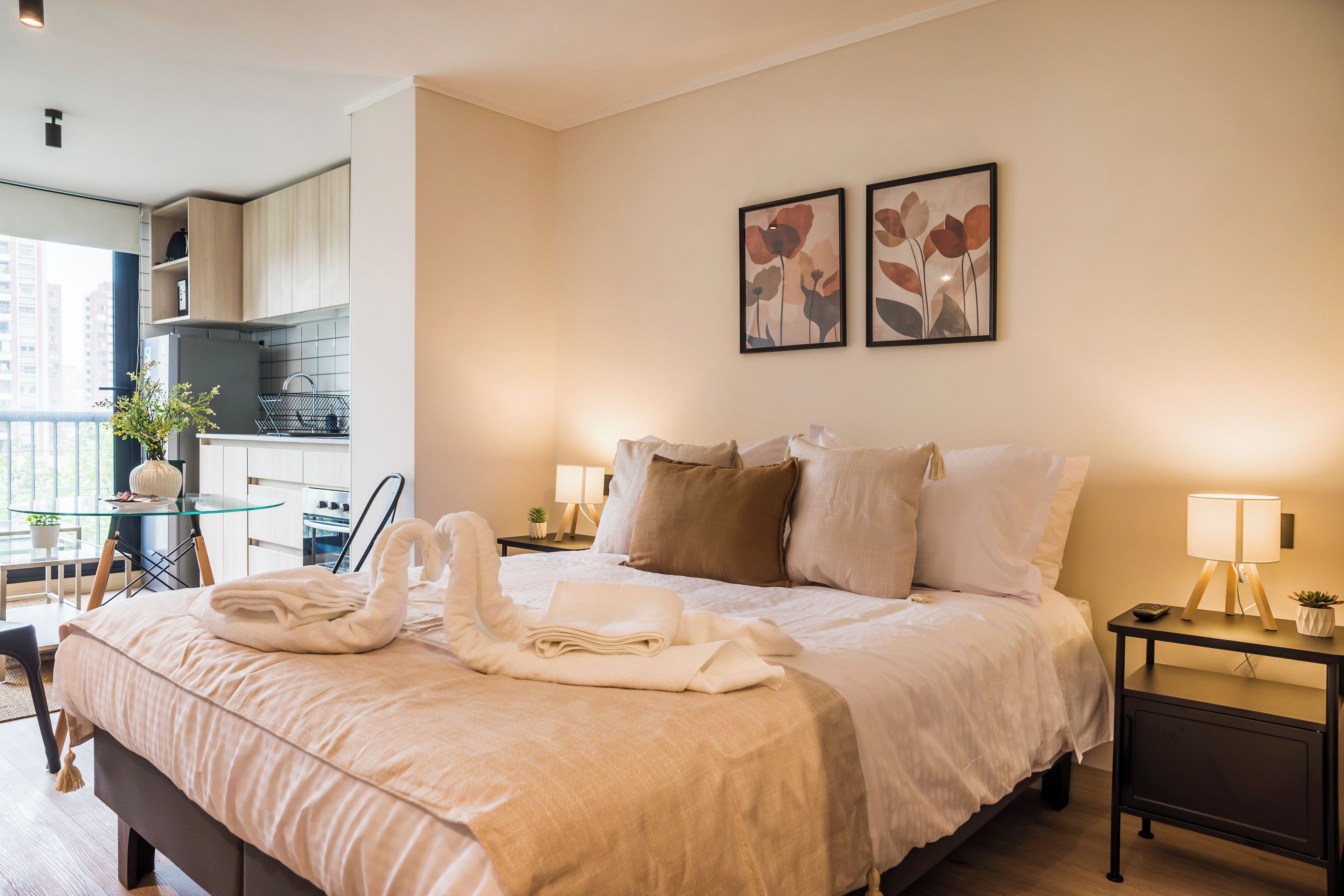 Une chambre d’hôtel avec un lit, des tables de chevet, un petit bureau et une vue sur l’extérieur.