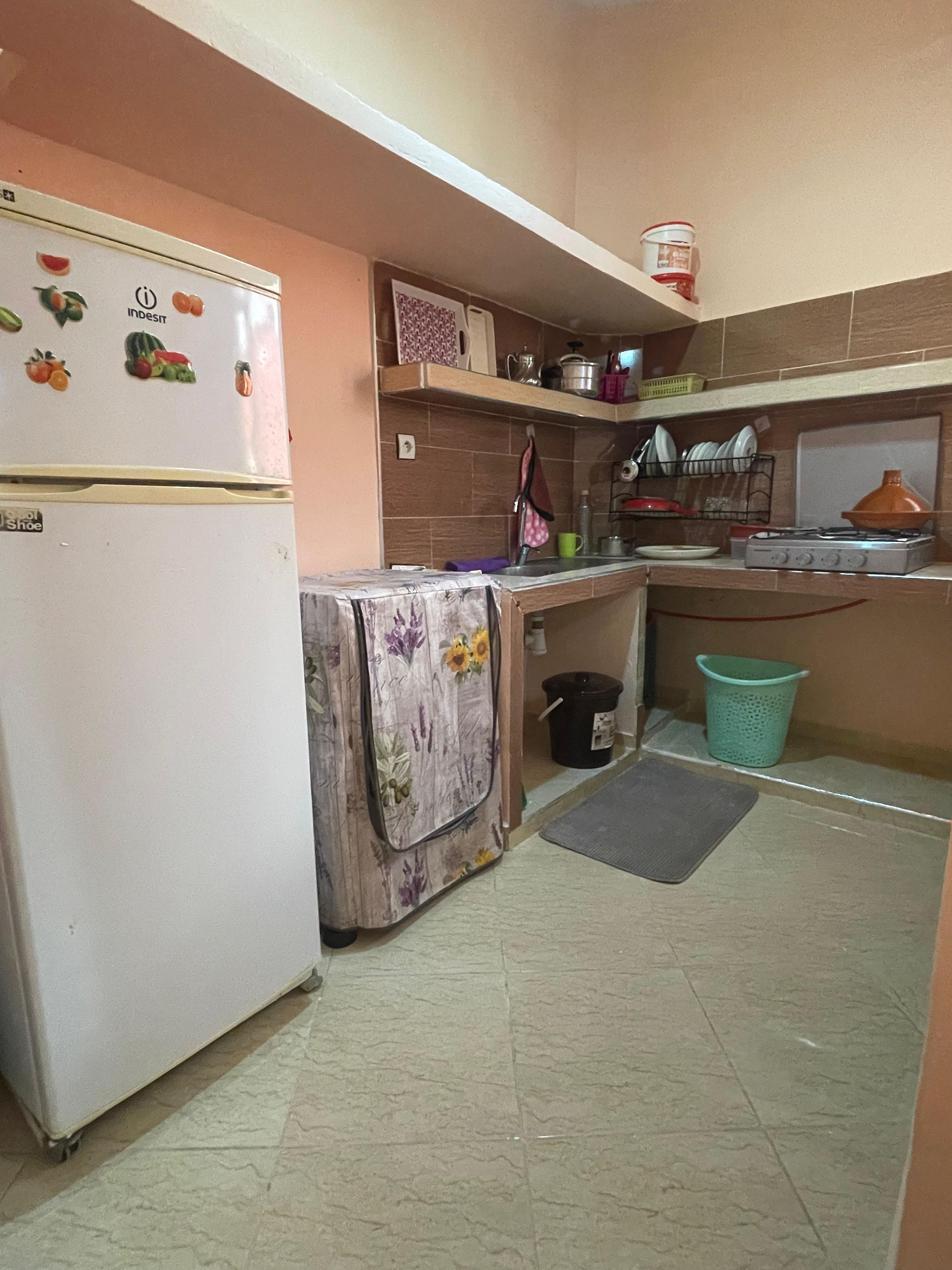 A compact kitchen with a refrigerator, a stove, and a sink.