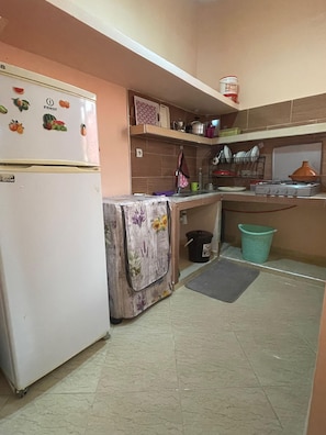 A compact kitchen with a refrigerator, a stove, and a sink.