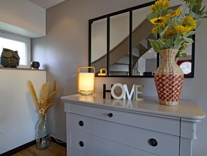 A white dresser with a mirror, a candle, and a vase with sunflowers. - Contemporary house near beach - 5 guests (Blainville-sur-Mer)