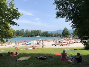 A beach with people sunbathing and swimming, surrounded by trees and a clear sky. - Family chalet with terrace - 6 guests (Baudreix)
