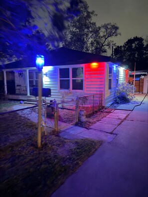 A house with a porch, a fenced yard, and a small garden. - Texas Oasis Retreat Near the Coast (Bay City)