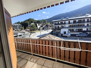 A balcony with a view of a street, buildings, and a mountain in the background. - Spacious apartment, parking - 7 guests. Slope view (Arâches-la-Frasse)