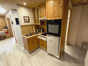 A compact kitchen with wooden cabinets, a built-in oven, and a dishwasher. - Spacious apartment, parking - 7 guests. Slope view (Arâches-la-Frasse)