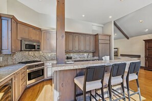 A spacious kitchen with a large island, stainless steel appliances, and wooden cabinetry. - Ski-In/Ski-Out Beaver Creek | Walk to Village (Beaver Creek)