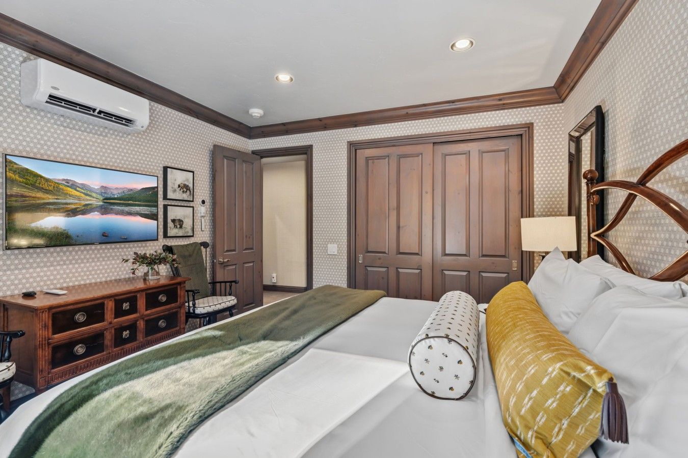 Une chambre d’hôtel équipée d’un lit, d’un bureau, d’une chaise, d’une télévision et d’une armoire.