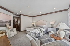 A hotel room with a bed, bedside tables, a desk, a chair, and a large window. - Ski-In/Ski-Out Beaver Creek | Walk to Village (Beaver Creek)