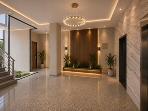 A modern lobby with a marble floor, a central light fixture, and a wooden panel wall. - Spacious 3BR Serviced Apartment Near Bole Airport (Addis Ababa)